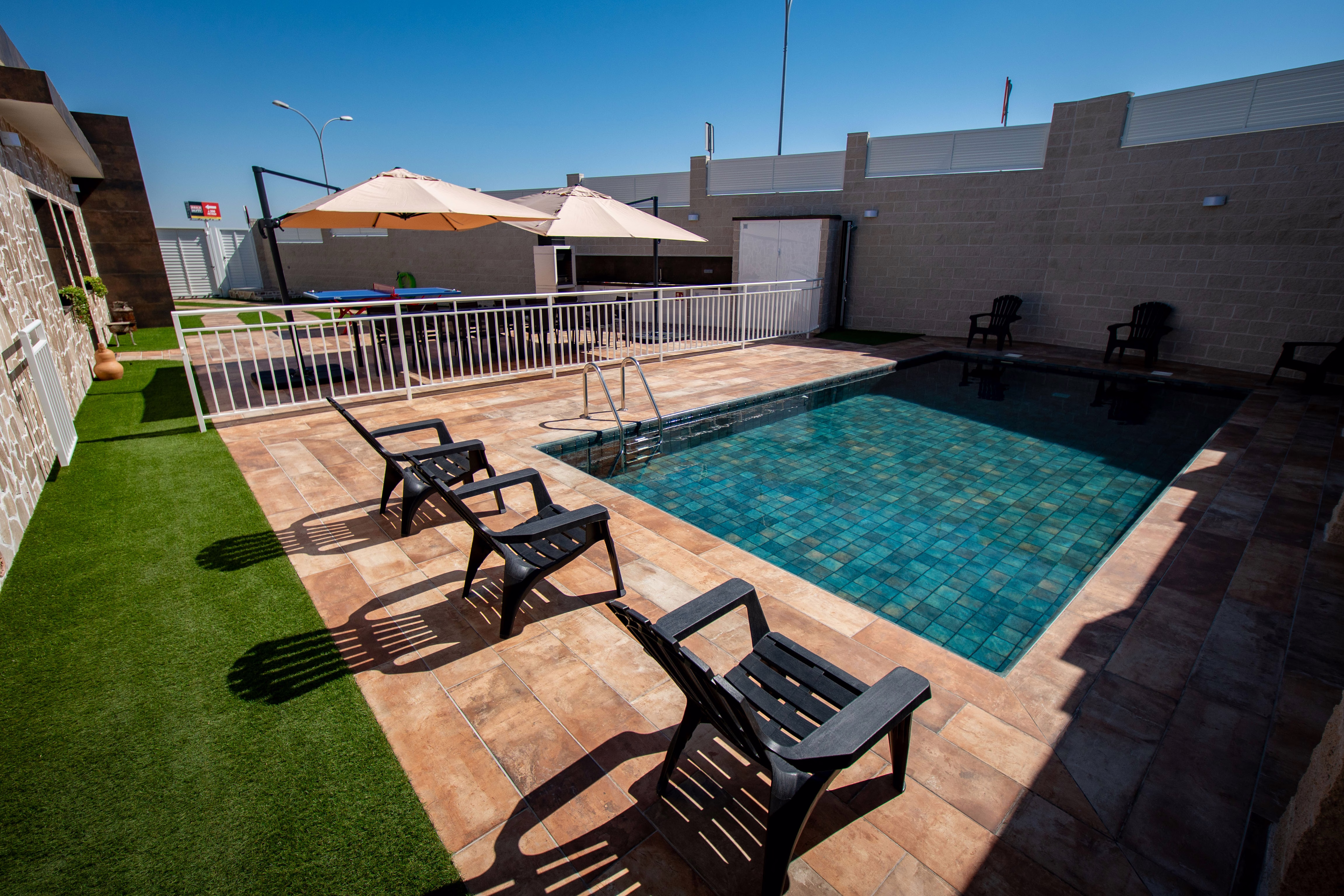 Zona de piscina con tumbonas y área para tomar el sol
